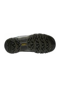 Shoe outsole with rugged black rubber, featuring multi-directional lugs for traction and a central logo. Durable textured surface.