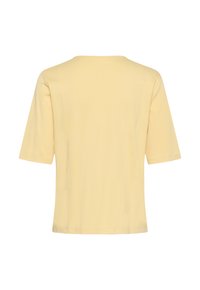 Haut à manches courtes de couleur jaune pâle unie avec un col rond et des détails de coutures visibles dans le dos.