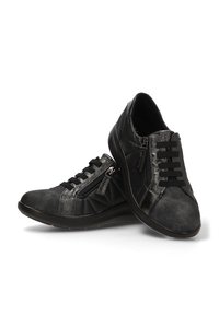 Zapatillas casuales negras con lados acolchados, cordones en la parte frontal y cremalleras laterales, exhibidas sobre un fondo blanco.