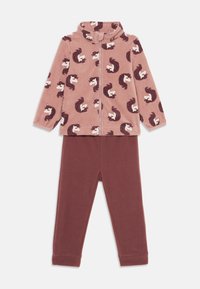 Fleece pysjamasett med en rosa zip-up topp med hvite og brune unicorn-mønstre, kombinert med ensfargede, maroon bukser. Myk tekstur, elastiske mansjetter.