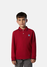 Polo shirt a maniche lunghe rosso con colletto blu navy e una patch rotonda blu. Tessuto morbido con una vestibilità classica e pattina con bottoni.