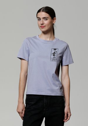 T-shirt en coton lilas à manches courtes, avec un imprimé graphique noir d'une figure et le texte "THE FOOL" sur le côté gauche.