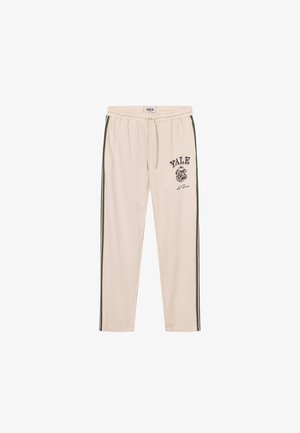 Kremvärdiga svettbyxor med gröna sidostråkar, elastisk midja och "YALE"-grafiktryck tillsammans med en bulldogssymbol.