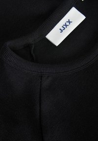 Fekete pamut pulóver anyag, bordázott nyakkal. A címke belül "JJXX" feliratot mutat. Puha tapintás, díszítések nélküli design és klasszikus forma.