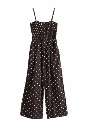 Brun jumpsuit med hvide prikker, der har justerbare stropper, en smocked bodice og et vidde ben design med sidelommer.