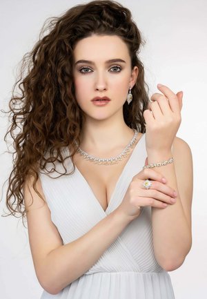 Jewelry set features a sparkling silver necklace with floral accents, matching earrings, bracelet, and ring with a central flower design.