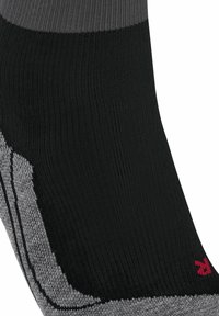 Zwart en grijs gestreepte sok met een geribbelde textuur, voorzien van een rood logo-accent aan de zijkant en een gladde stofontwerp voor comfort.