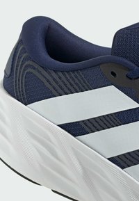 Navy running shoe with white thick sole, white stripes on side, padded collar, and breathable mesh fabric upper.