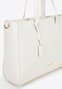 Witte leren tote bag met dubbele handvatten, rechthoekige vorm, gouden hardwareaccenten en een subtiele textuur op het oppervlak. Bevat het merkembleem.