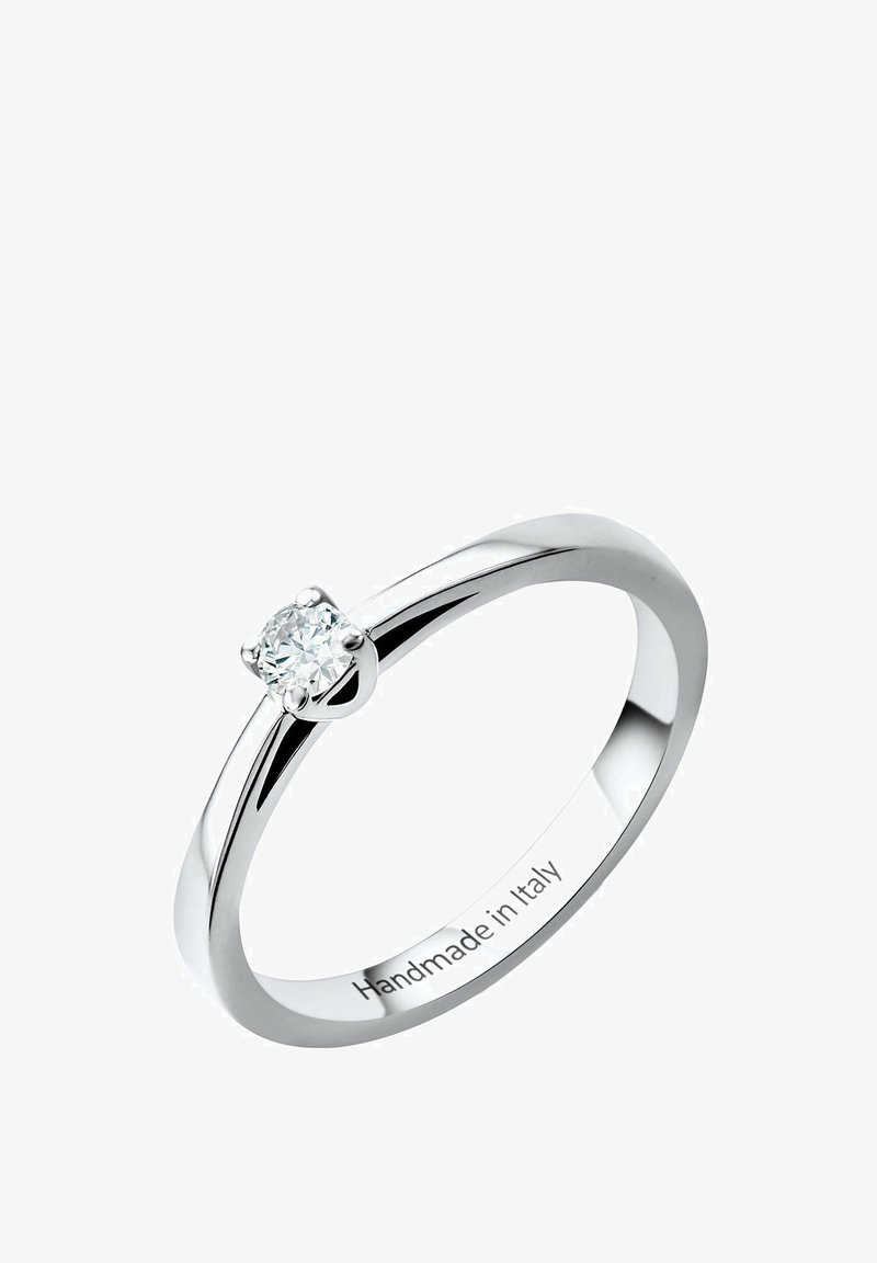 Vitguld ring med en enda rund diamant som är inställd i en fyrklolig infattning. Inuti ringen är det graverat "Handgjord i Italien."