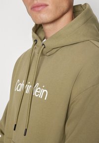 Calvin Klein HERO LOGO COMFORT HOODIE - Felpa - delta green