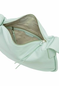 Sac à main en cuir vert menthe clair avec une forme arrondie. L'intérieur est doté d'une doublure beige lisse et d'une poche zippée.