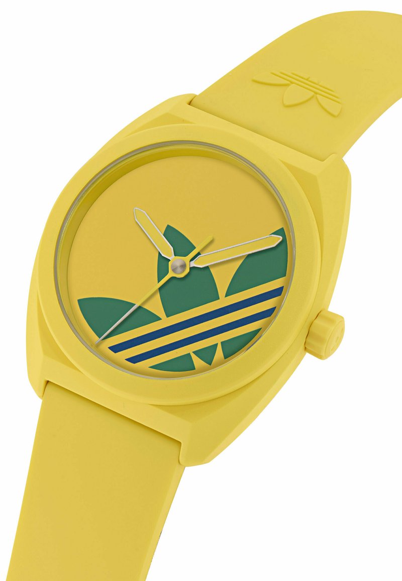 Gele siliconen horloge met een ronde wijzerplaat met een groen bladontwerp, blauw-gele strepen en zilveren wijzers.