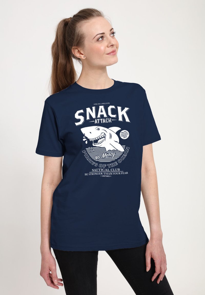 Marinblå bomulls t-shirt med en vit grafik som har en hajillustration och fet text som säger "SNACK ATTACK." Avslappnad design med korta ärmar.