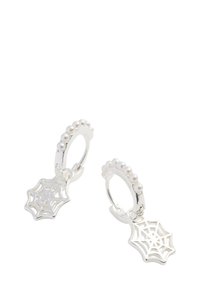 Orecchini a cerchio in argento con un design a perline, dotati di un piccolo charm a forma di ragnatela. La superficie è lucida e presenta una texture liscia.