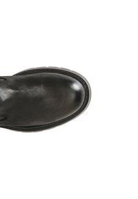 Bota de tobillo de cuero negro con punta redondeada, superficie texturizada y costuras blancas en la suela contrastantes. Diseño minimalista sin hardware visible.