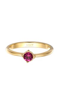 Kuldne sõrmus, mille keskel on ümar roosa kivi, paigaldatud lihtsasse nelja haardega disaini. Sile sõrmus, mille sees on märgistus "Ag 925".