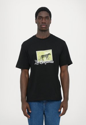 T-shirt en coton noir avec un graphisme coloré d'un léopard et le texte "Les Benjamins". Manches courtes, design classique à col rond.