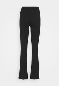 Pantalons évasés noirs à côtes avec une taille ajustée, tissu texturé et une finition brute au bas, conçus pour une silhouette ajustée.
