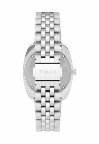 Montre Timex en métal argenté avec bracelet en maillons et fermoir, vue de l'arrière, mettant en évidence le nom de la marque gravé sur le fermoir.