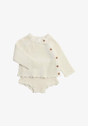 Flødefarvet strikket babytøj med langærmet top med fire sideknapper og matchende shorts med flæser.
