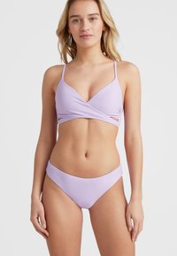 Šviesiai violetinis bikini, pasižymintis apvijamąja konstrukcija su išpjovomis, plonomis dirželiais ir lygiu, matinio paviršiaus tekstūra. Paprasta, modernaus silueto forma.