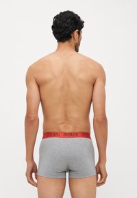 Szürke boxeralsó, piros Puma logós elasztikus derékpánttal, testhez álló fazonban, puha tapintású anyagból, hátulról nézve.