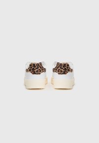 Sneakers bianchi con una finitura liscia, dotati di un accento in suede a stampa leopardata sul tallone. Suola platform, design minimalista.
