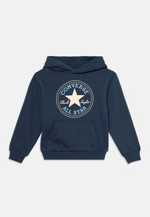Тъмносиньо худи Converse с преден джоб и кръгло лого с звезда и текст "Chuck Taylor All Star" в бяло и светлосиньо.