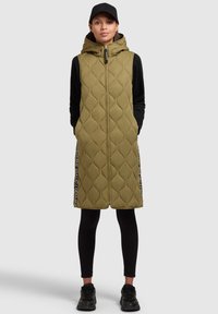Gilet imbottito verde oliva con cappuccio e zip frontale, dotato di tasche laterali e dettagli neri con testo bianco lungo i bordi.
