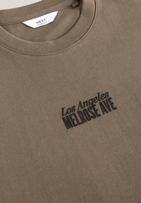 Olivgrünes Sweatshirt aus Baumwolle mit rundem Halsausschnitt und schwarzer Frontbeschriftung: "Los Angeles MELROSE AVE".