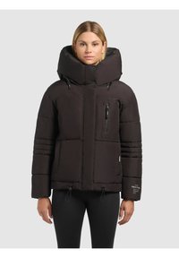 Črna napihnjena jakna z visokim ovratnikom, zadrgami na žepih in elastičnimi vrvicami na robu. Ima prešito zasnovo in mehak material.