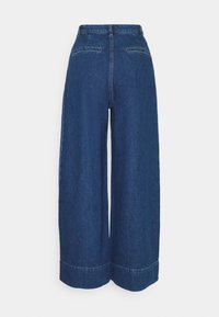 High-waisted wide-leg dark blue denim pants with cuffed hems and two back welt pockets.