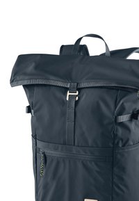 Dark blue roll-top backpack made of durable material, featuring a top clasp, side pocket with zipper, and adjustable straps.