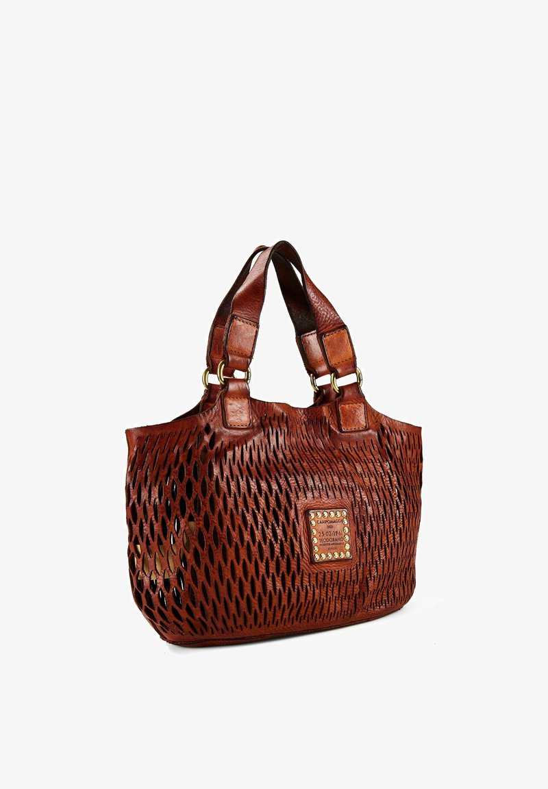 Bolso tote de cuero marrón con patrón de diamantes perforados, asas dobles y una etiqueta central cosida adornada con tachuelas metálicas.
