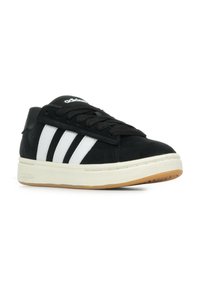 Czarne zamszowe sneakersy z trzema białymi paskami, czarnymi sznurówkami i beżową gumową podeszwą. Posiadają wyściełany kołnierz i teksturowaną górną powierzchnię.