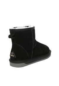 Schwarze Wildleder-Ankle Boots mit einem weichen Kunstfell-Futter, runder Spitze und Gummisohle. Hinterer Fersenzug für ein einfaches Anziehen. Markenlogo sichtbar.