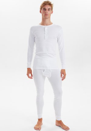 Hvid termisk top med lange ærmer, rund halsudskæring og knaplukning, parret med matchende termiske leggings. Glat bomuldsstruktur.