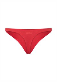 String en coton rouge avec une texture lisse, ceinture élastique et design minimaliste. Présente un logo subtil imprimé à l'avant.