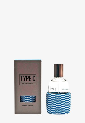 Eau de Toilette in einer klaren Glasflasche mit einem silbernen Deckel, umwickelt mit einem blauen und weißen Strickstoff. Kommt in einer grauen Box mit einem Ausschnitt.
