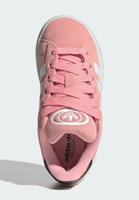 Pink suede sneaker with white stripes, textured laces, and logo on tongue. Features a round toe and cushioned insole. Black outsole.