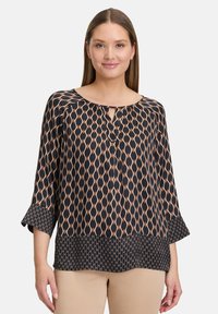 Czarna i beżowa bluzka w wzory z dekoltem w kształcie łódki, detalem w kształcie otworu, rękawami o długości trzy czwarte i teksturowanym dołem.