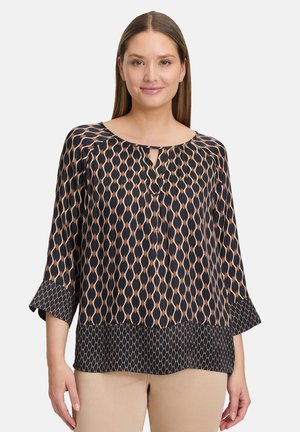 Blouse à motif noir et beige avec un décolleté arrondi, un détail en trou de serrure, des manches trois-quarts et un ourlet texturé.