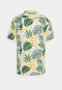 Lyhyet hihat omaava paita, jossa on valkoinen pohja ja kirkkaankeltaisia kukkia sekä vihreitä trooppisia lehtiä, mikä korostaa rentoa ja epämuodollista muotoilua.
