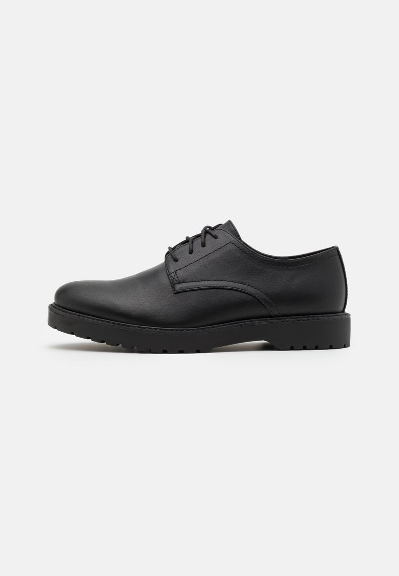 Black leather dress shoe with a rounded toe, classic lace-up design, and textured surface. Features a sturdy black rubber sole.