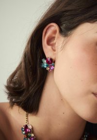 Bunte florale Ohrringe mit pinken, blauen und grünen Edelsteinen in einem vergoldeten Rahmen, verziert mit feinen Details und geschichteten Formen.