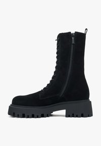 Czarne zamszowe botki za kostkę z grubą teksturowaną podeszwą, z przodu sznurowane, z bocznym zamkiem błyskawicznym dla łatwego zakładania. Posiadają pętelkę u góry.