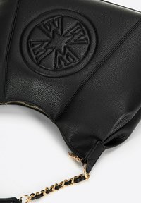 Schwarze Lederhandtasche mit eingeprägtem kreisförmigen Logo, strukturiertem Oberflächenmaterial, goldener Kettenakzent und Reißverschluss. Kompaktes rechteckiges Design.