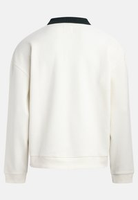 Cream-colored sweatshirt with a black ribbed collar, relaxed fit, long sleeves, and a textured fabric. Features a slightly cropped hem.