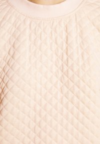 Rosa gesteppter Sweatshirt mit einem Rautenmuster, ausgestattet mit einem gerippten Rundhalsausschnitt und weichem Material.
